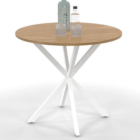 Table ronde Alix à plateau effet bois et pied araignée blanc dans une salle à manger lumineuse.