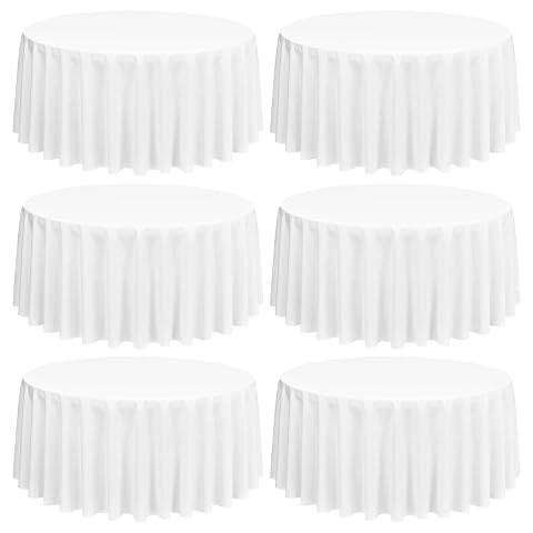 Nappe ronde blanche en polyester sur une table en bois, accompagnée de cinq nappes pliées