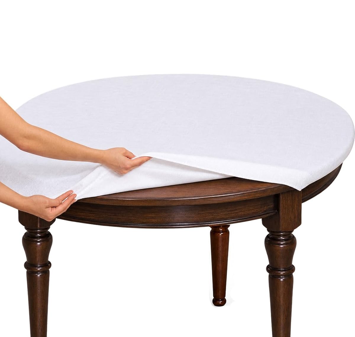 Protège-table rond blanc en molleton polyester placé sous une nappe sur une table en bois clair.