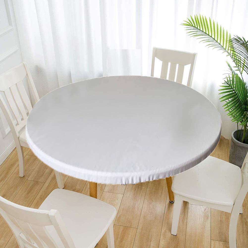 Nappe ronde blanche en vinyle à bords élastiques posée sur une table en bois naturel.