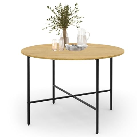 Table ronde au plateau aspect bois et aux pieds noirs dans une salle à manger lumineuse