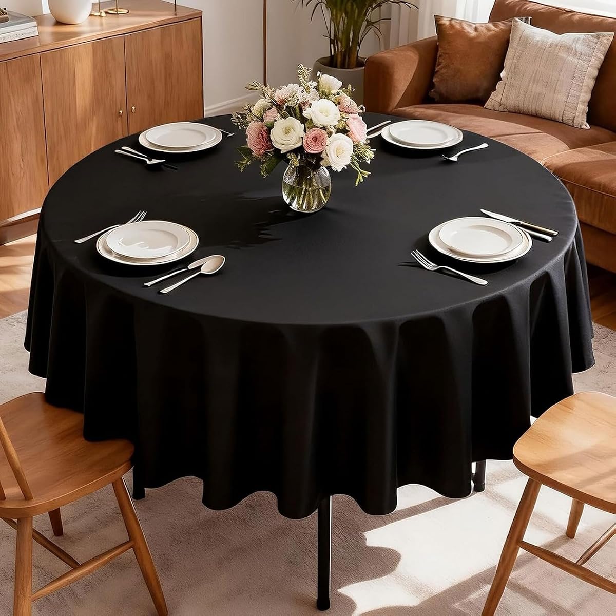 Nappe ronde noire en polyester de 178 cm déployée sur une table à manger ronde.