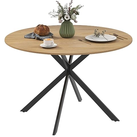Table ronde aspect chêne avec plateau mélaminé et piètement croisé en acier noir.