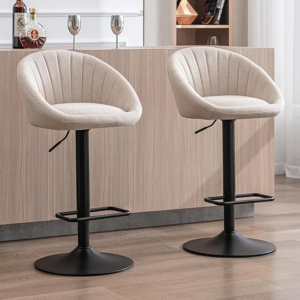Deux tabourets de bar beige en tissu, réglables et pivotants, avec repose-pieds et piètement métallique