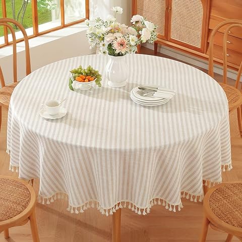 Nappe ronde beige à rayures en coton et lin posée sur une table en bois naturel