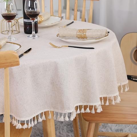 Nappe ronde beige à franges posée sur une table en bois dans une salle à manger lumineuse