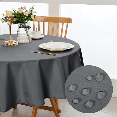 Nappe ronde gris clair en polyester posée sur une table circulaire en bois naturel.