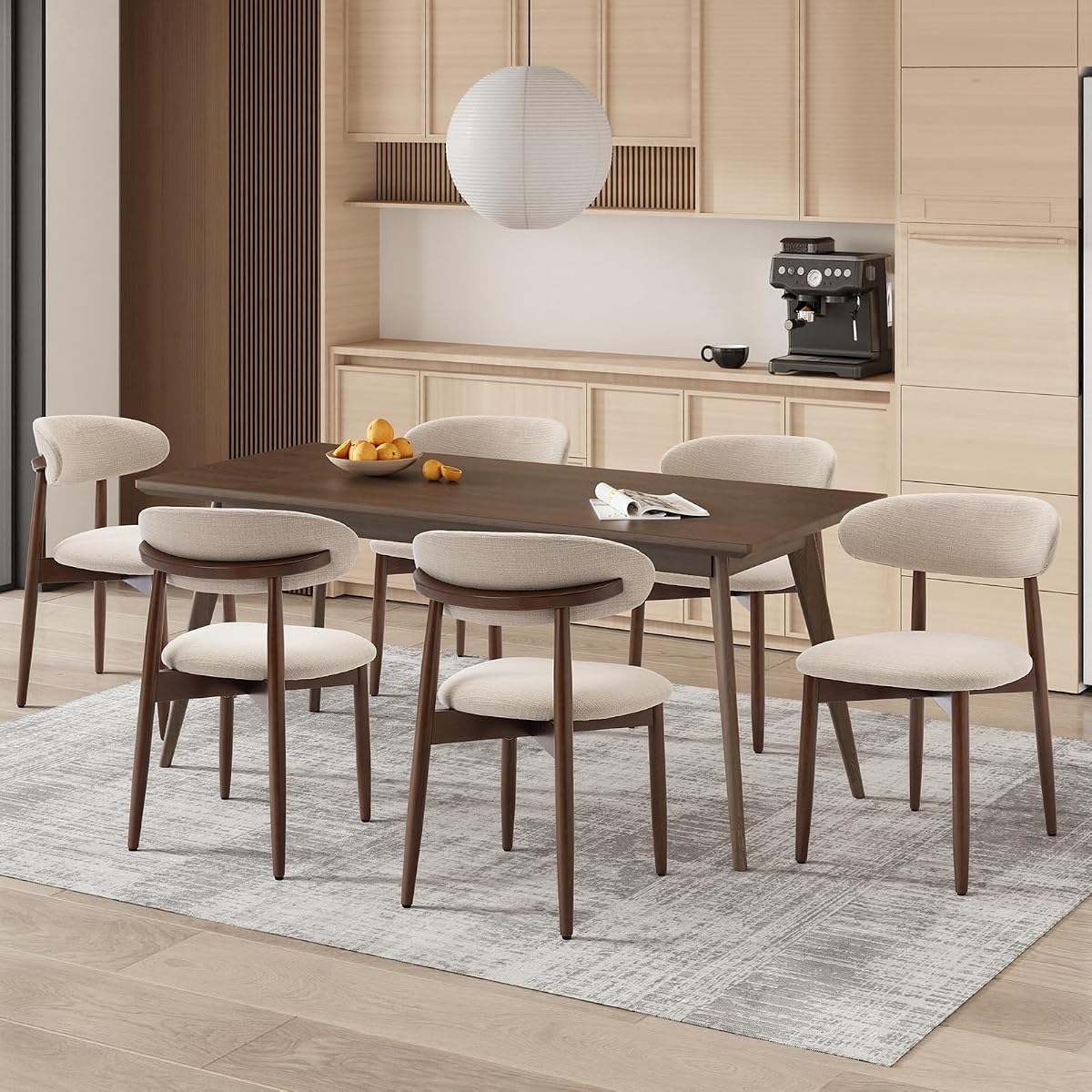 Six chaises beige à assise rembourrée et pieds en bois disposées autour d’une table ronde.