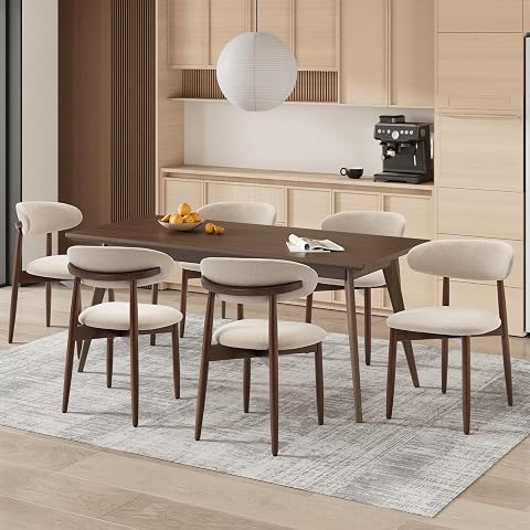 Six chaises beige à assise rembourrée et pieds en bois disposées autour d’une table ronde.
