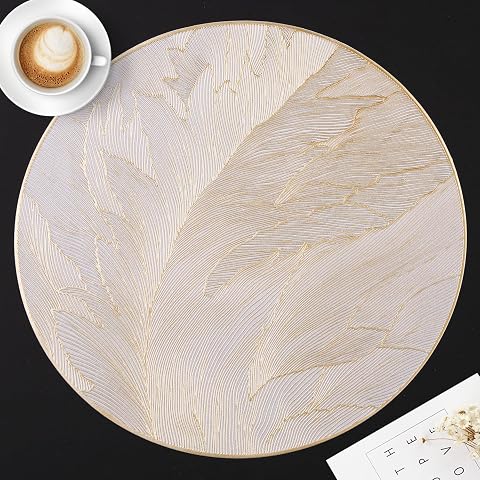 Six sets de table ronds en PVC à motif de plumes dorées, présentés sur une table en bois naturel