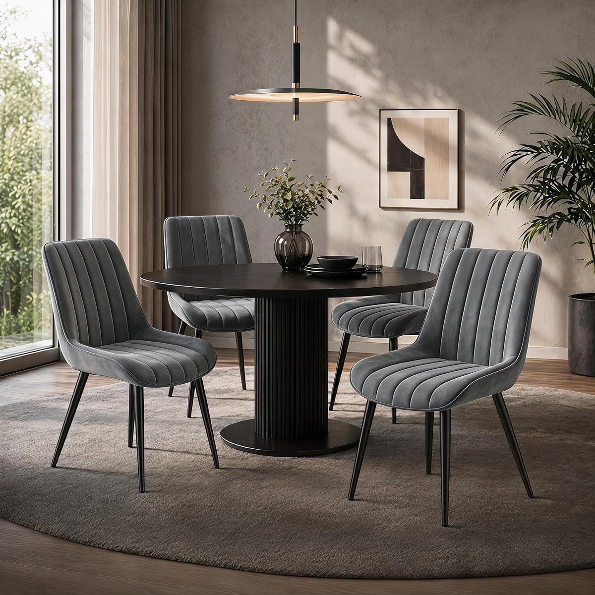 Quatre chaises en velours gris foncé à dossier incurvé autour d’une table ronde