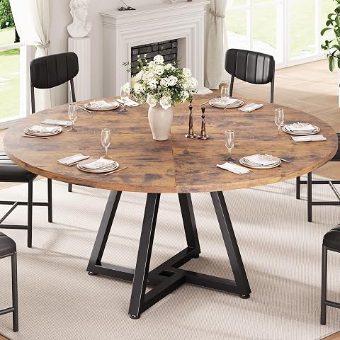 Table ronde à plateau effet bois rustique et piètement croisé en métal noir dans un intérieur lumineux